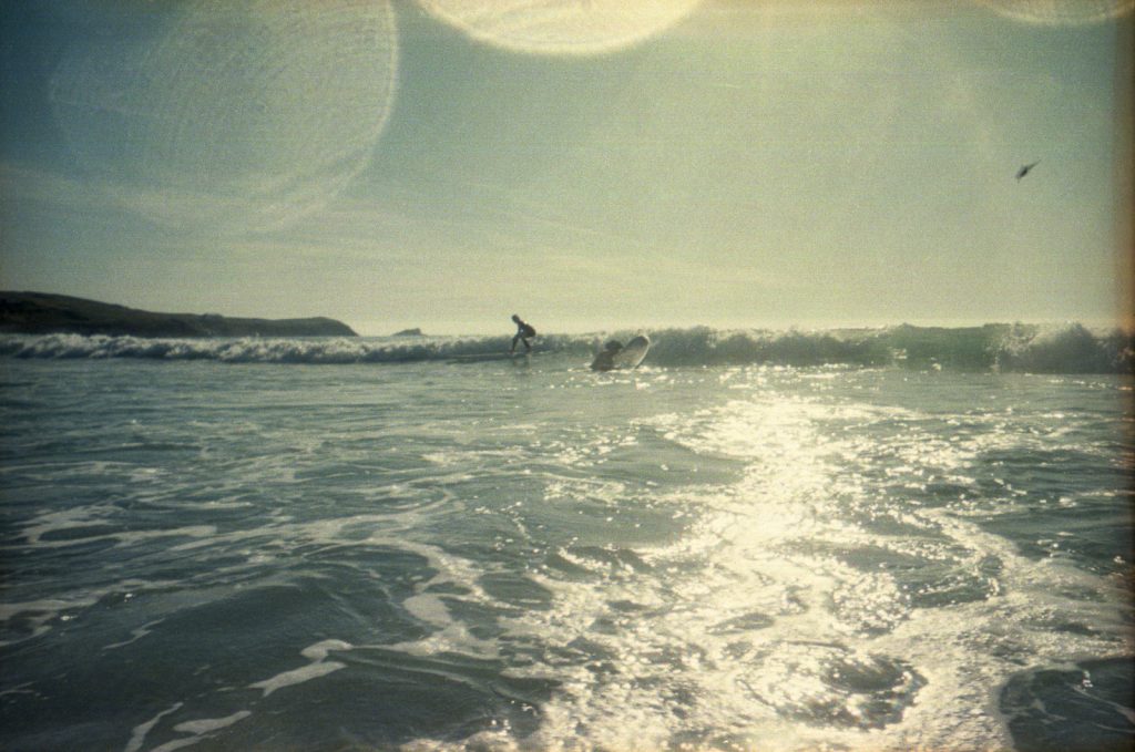 Surfer riding a wave photographed with a waterproof disposable camera in Newquay, Cornwall