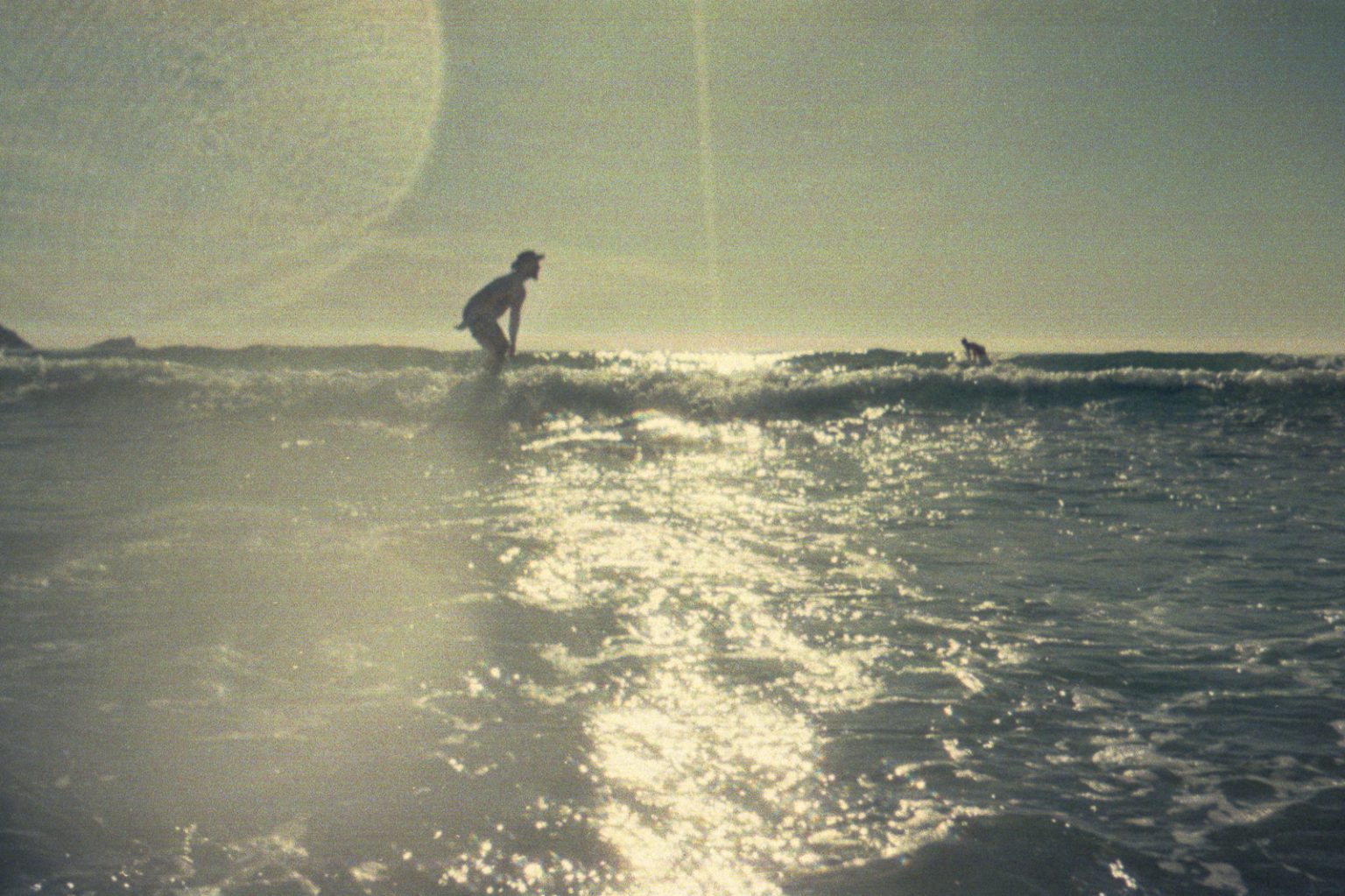 Using a 35mm SLR Underwater: Testing an Olympus OM-10 with the EWA Marine Housing Surfer riding a wave photographed from the water with a Kodak waterproof disposable camera in Newquay, Cornwall.